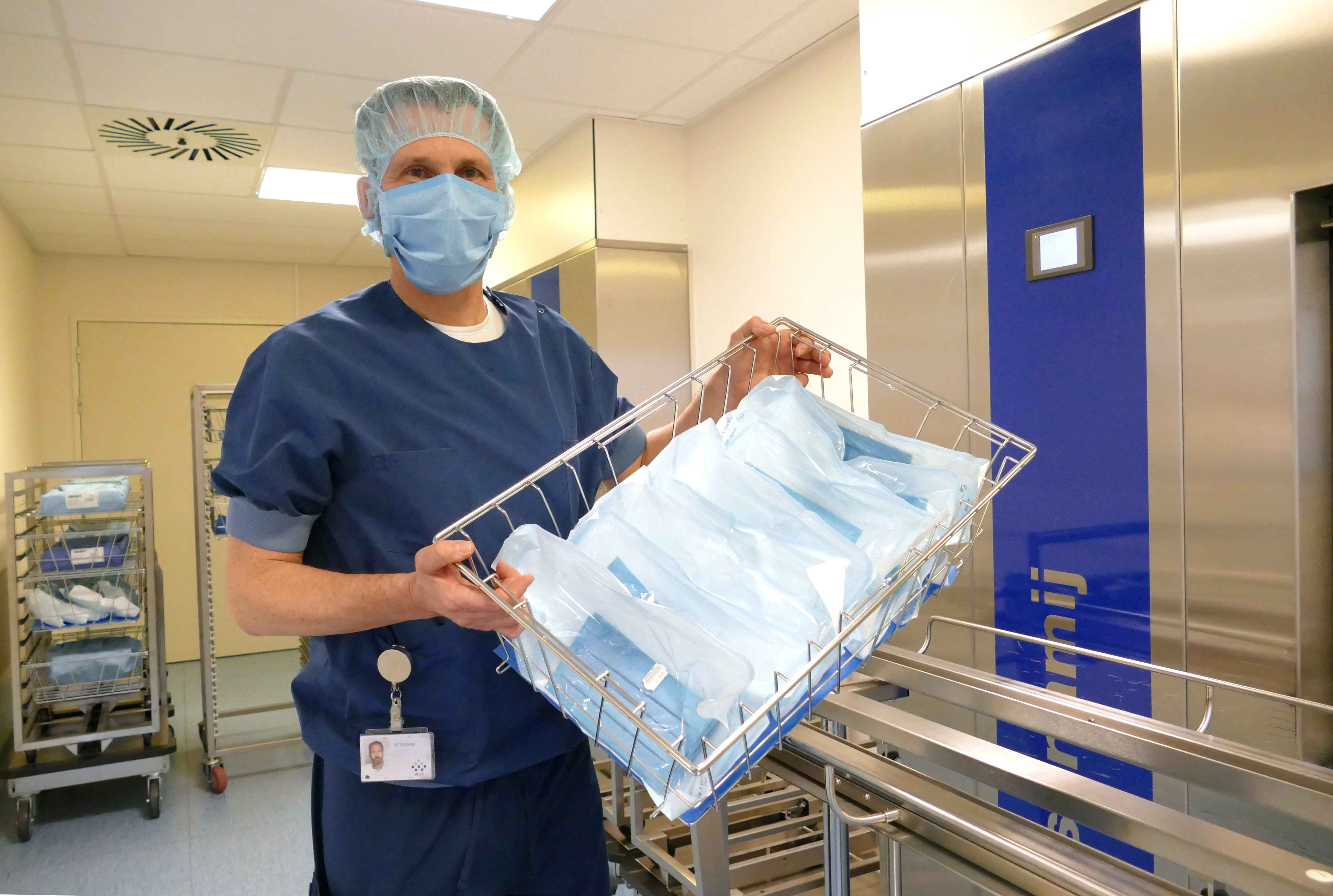 Medewerker Nico met mand gesteriliseerde mondkapjes